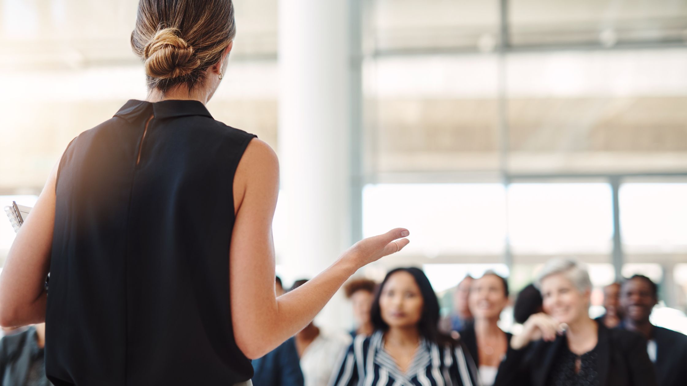 Woman speaking to an audience in a room, sharing an inspiring message about storytelling and impact.